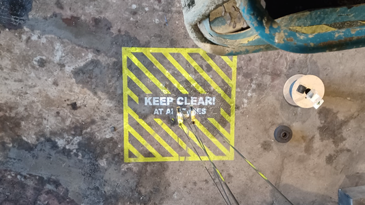 Projected signage of a hatched floor marking on a warehouse floor to improve crane safety.