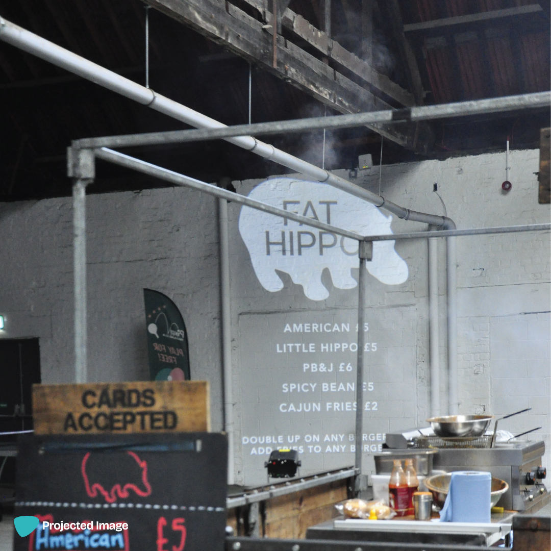 Gobo projection on a warehouse wall with the 'Fat Hippo' Menu