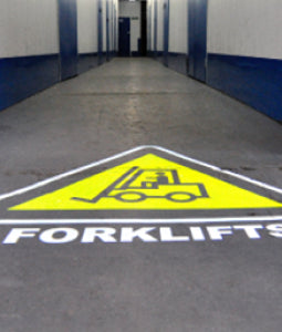 Forklift safety sign projected onto a warehouse floor using a gobo projector.