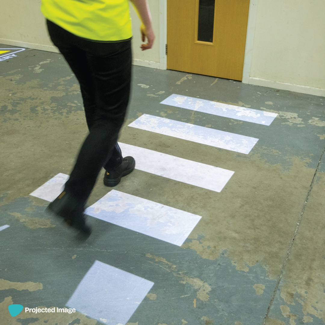 Warehouse safety signage of a zebra crossing, using an LED gobo projector.