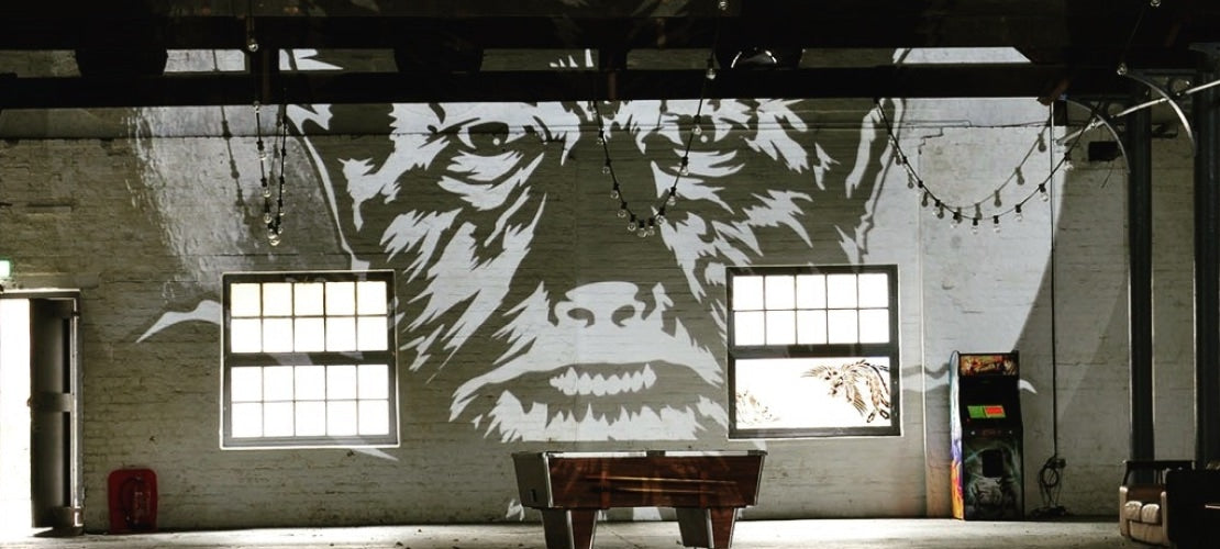 Large scale gobo projection of a werewolf on a white brick wall.