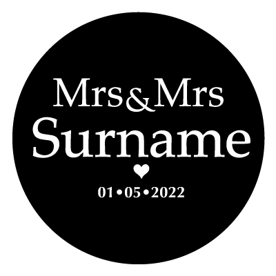 White "Mrs & Mrs Surname" text with a small white heart below. Underneath the small heart is the text "01.05.2022" in white. All on a black circle.