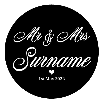 White "Mr & Mrs Surname" text with a small white heart below. Underneath the small heart is the text "1st May 2022" in white. All on a black circle.