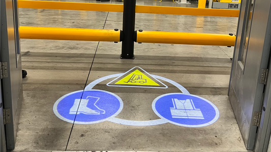 Projected sign in a warehouse showcasing a forklift truck warning and PPE signs