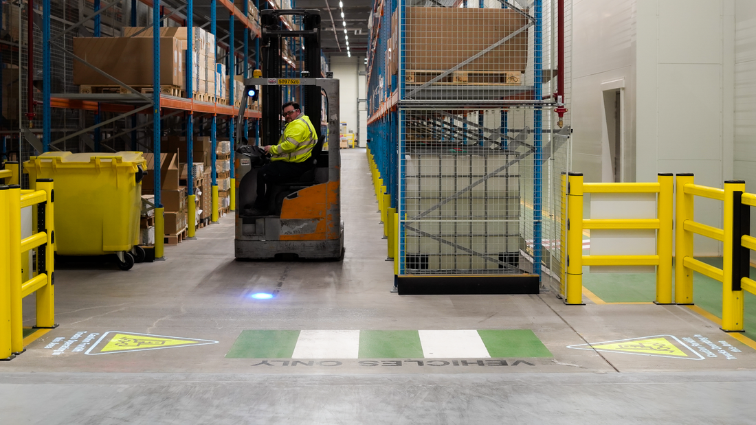 Warehouse showcasing projected safety signs to improve forklift safety.