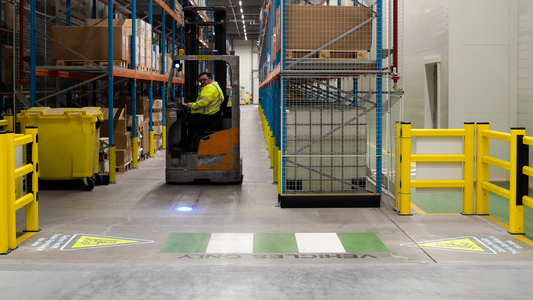 Warehouse showcasing projected safety signs to improve forklift safety.