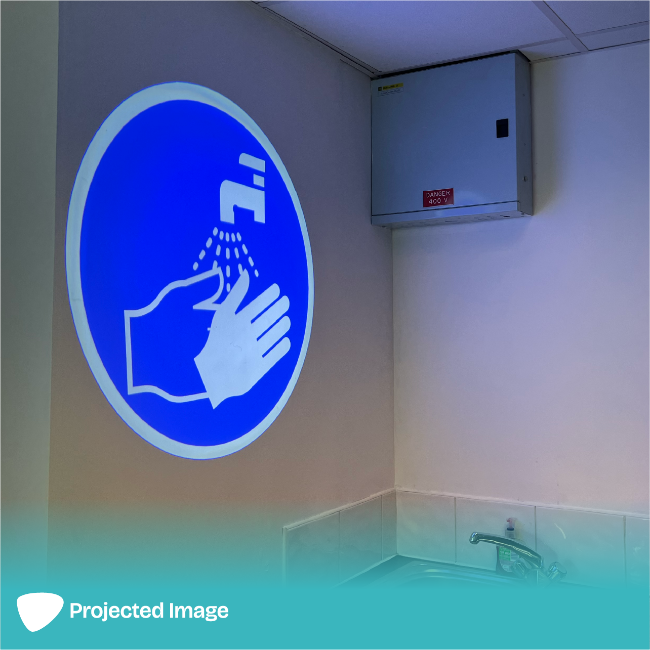 Projection of a 'Hand Washing' sign on a wall