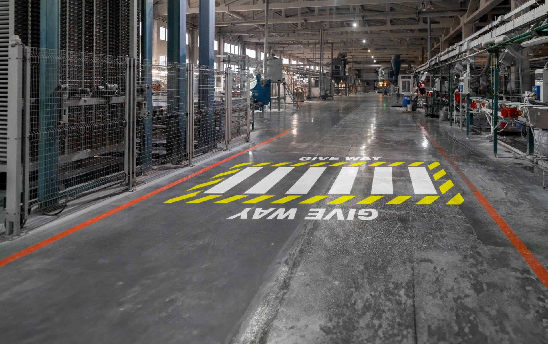 Give way floor marking and zebra crossing sign projected onto a warehouse floor.